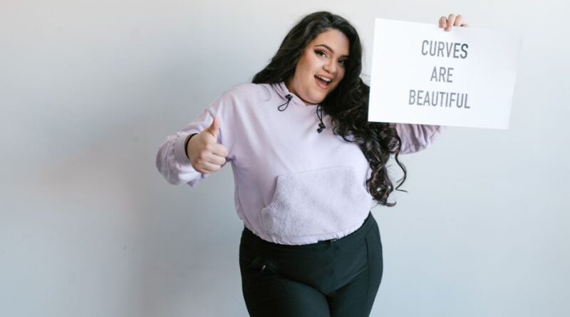 kobieta z kartką z napisem "Curves are beautiful"