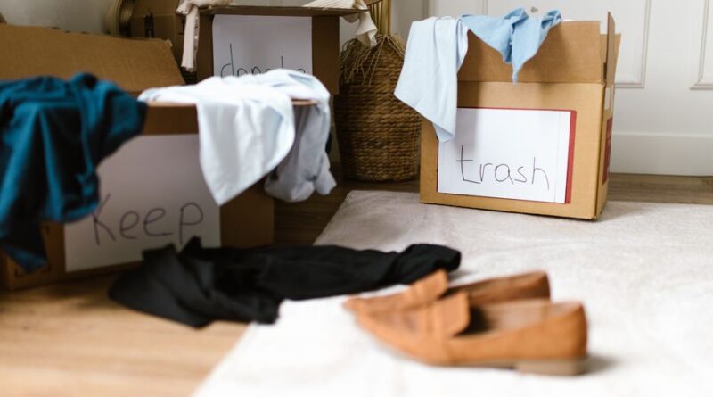 Trzy kartony z napisami „Keep”, „donate” i „trash” wypełnione ubraniami.
